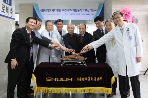 서울대치과병원 관계자들이 지난 14일 병원 2층 로비에서 열린 재활물리치료실 개소식에서 기념케이크를 자르고 있다.